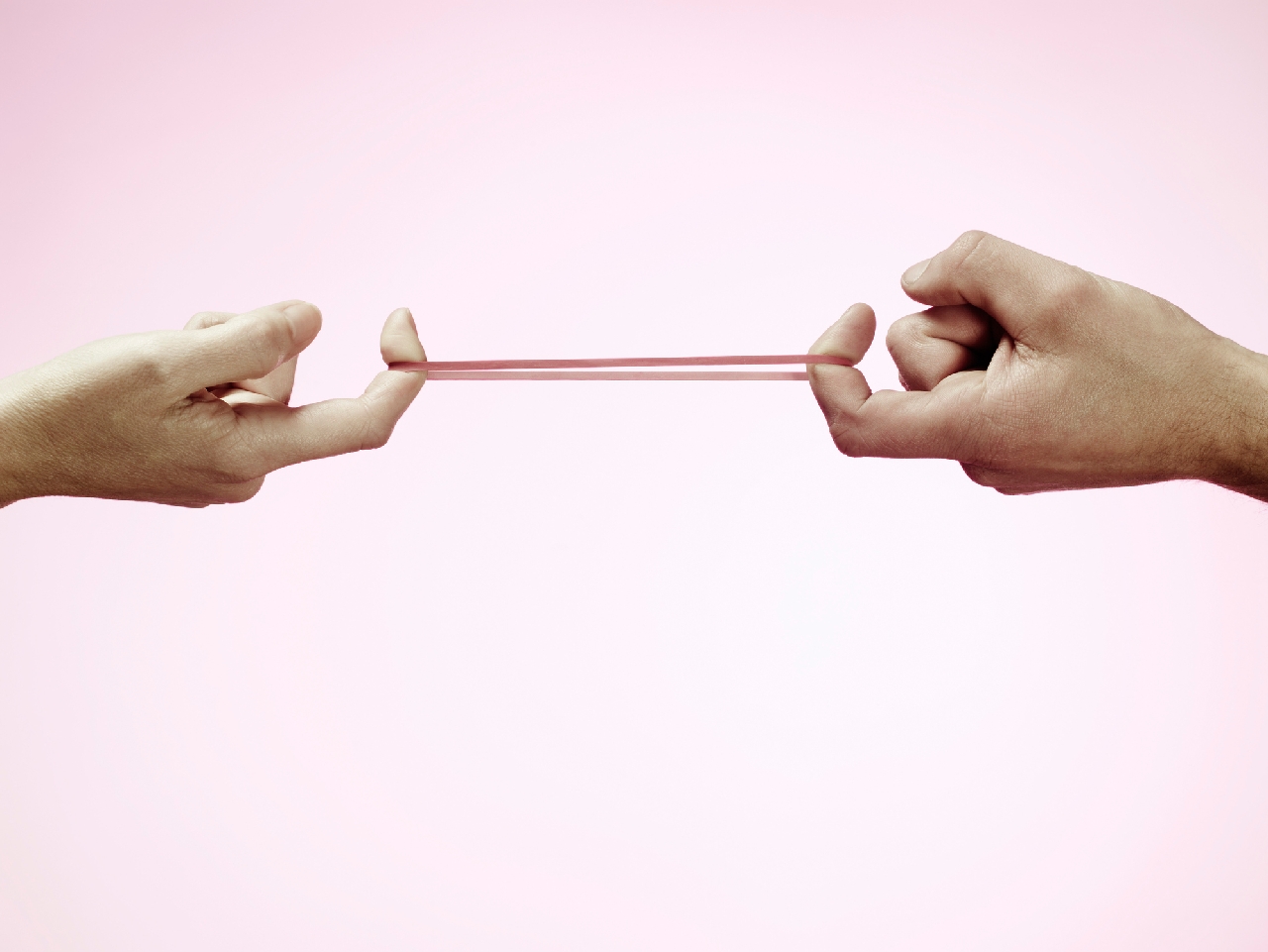 Image of two hands pulling on a rubber band