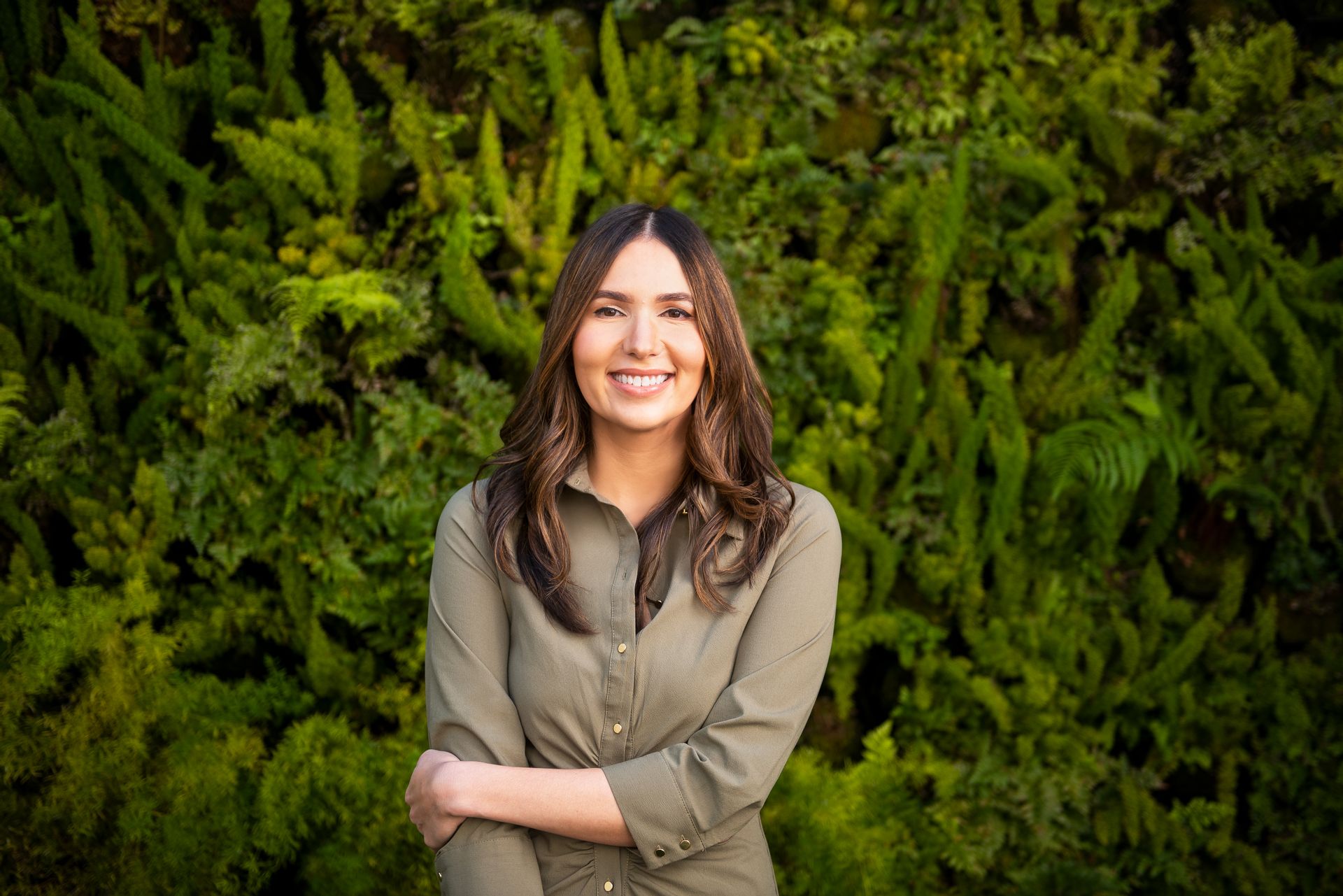 克里斯蒂娜·科尔多瓦（Cristina Cordova）与绿色植物墙的照片