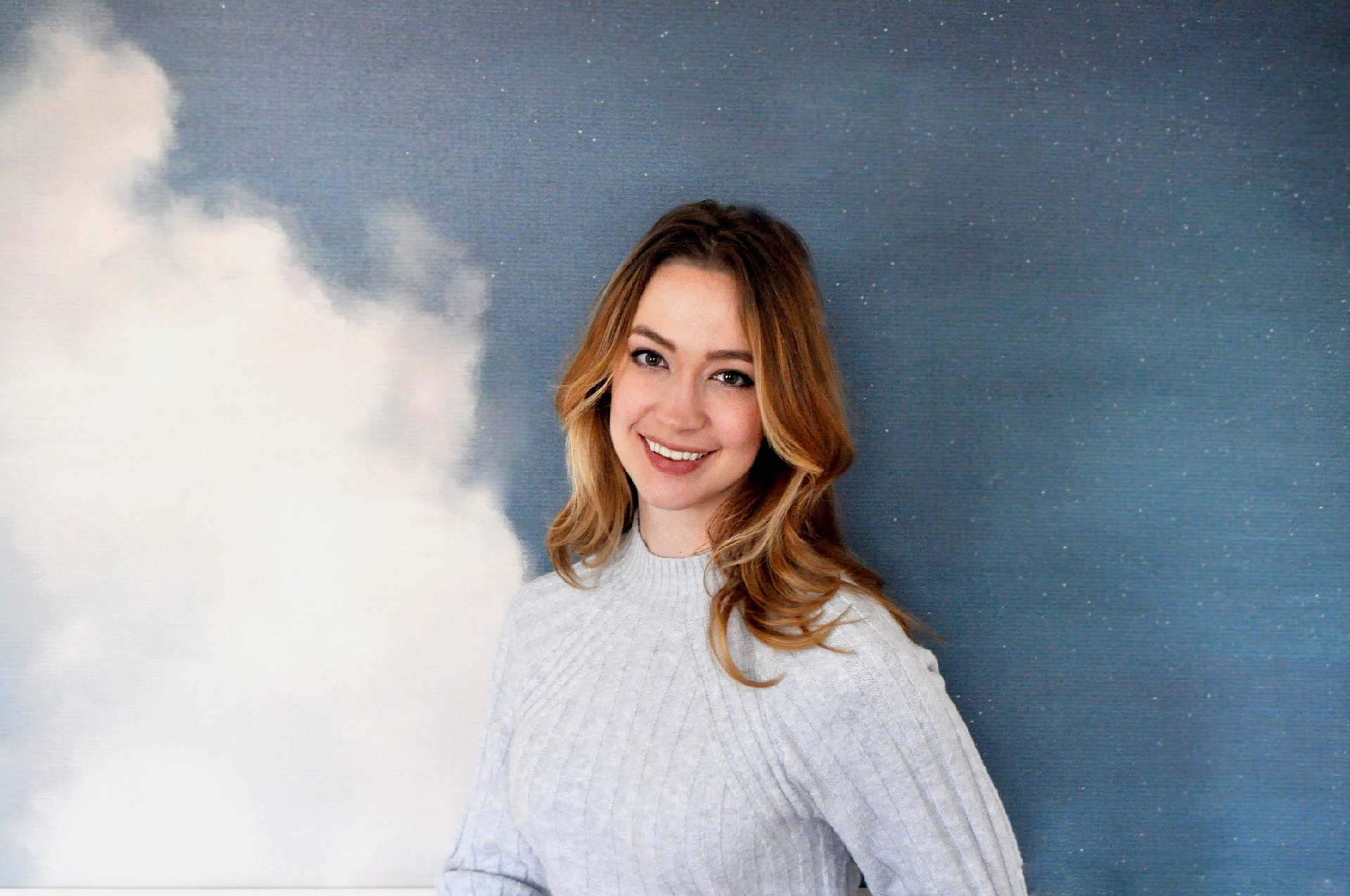 Photo of Kaitlyn Knopp against a blue background with a cloud