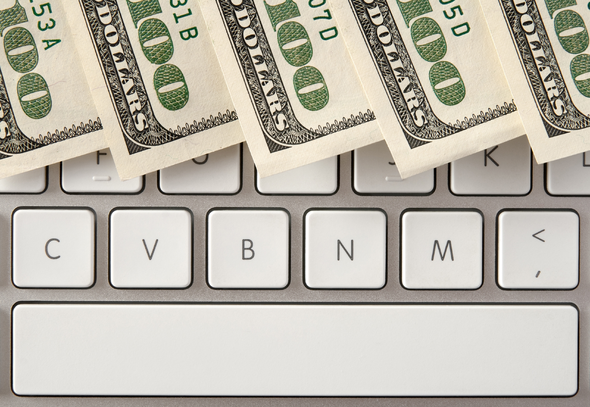 Hundred dollar bills against an Apple keyboard